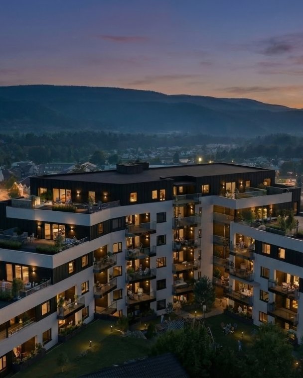 Elegant boligkompleks med utsikt over byen ved solnedgang.