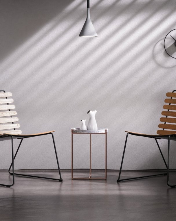 Elegant stue med to moderne stoler og minimalistisk veggdekor.